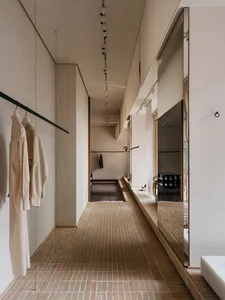Modern minimalist clothing retail store with brick tiled floor and minimalist interior design.