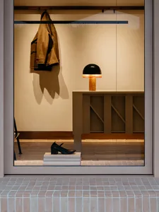 A minimalist retail storefront featuring a wooden counter and a modern light fixture.