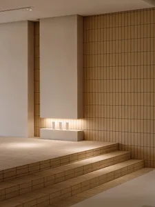 Minimalist staircase with tiled steps and a concrete wall.
