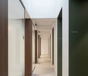 Modern interior design featuring glass walls and wooden columns in a corridor or hallway.