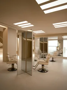 Modern salon interior with mirrors, leather, and cement floors