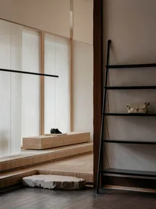 A minimalist shoe store interior with a brick counter and a black ladder with a leather bag.