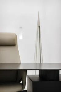 A minimalist office with a sleek, modern metal table and a comfortable, beige leather chair.