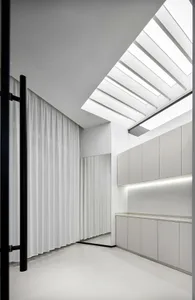 Modern bathroom featuring white concrete tiles and glass elements.