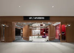 現代店面，設有木質柱子、玻璃門、金屬欄杆，以及地毯地板。