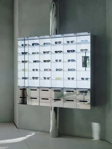 A glass display case filled with various sunglasses arranged neatly on shelves.