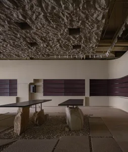 Minimalist cafeteria with terrazzo flooring and stone tables.