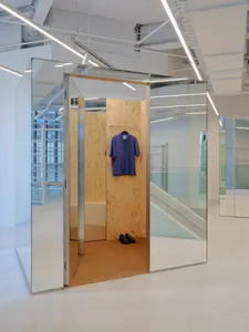 Minimalist clothing store interior with a metal, glass, and wood design.