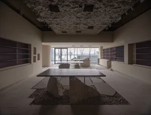 A minimalist restaurant interior with natural stone and concrete finishes.