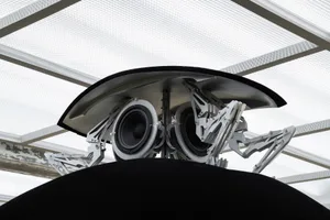 A minimalist robot featuring metallic components, black and white color scheme.