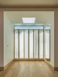 Minimalist room with wooden floor and cloth-covered dividers.