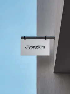 A minimalist signboard made of steel with the name 'Jiyong Kim' on it.