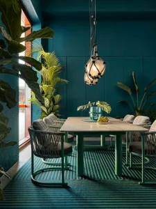 Modern dining room with a metal table and green chairs.