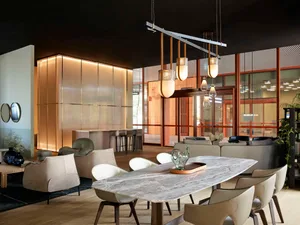 A modern living room featuring a marble dining table, leather chairs, and wooden flooring.