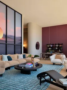 Modern living room featuring plush fabric seating, wooden accents, and a glass coffee table.