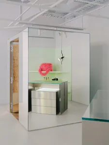 Modern retail showroom with metallic surfaces, glass shelves, and fluorescent lighting