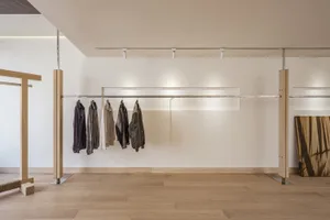 服裝店內部，現代金屬衣架展示各式服飾。