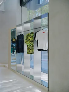 Clothing store display featuring retro-inspired clothing items such as a green and yellow acid-bright blouse, a white t-shirt