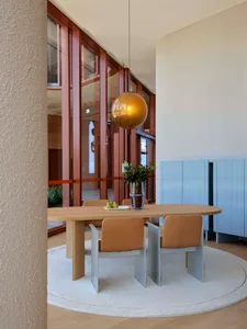 Modern dining room with wooden table, metal chairs, and glass pendant light.