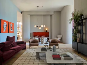 A modern interior living room with a marbled coffee table, leather armchairs, and a concrete column.