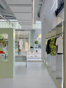 A modern retail store interior featuring concrete, glass, and metal materials.