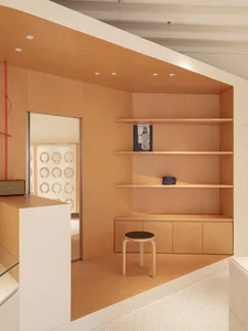 A minimalist interior with wooden shelves and a stool.