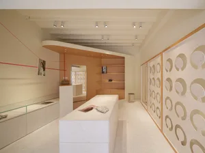 A modern retail store interior with minimalist design, featuring wood and concrete elements.
