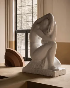 A large abstract sculpture made of stone, featuring a gestural pose with exaggerated forms and smooth, flowing lines.