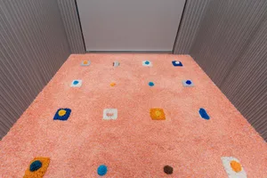 A textured, industrial-style carpet with colorful patterns