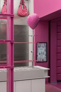A minimalist retail display featuring glass and pink accents.