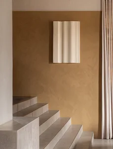 Minimalist staircase with concrete steps and a textured plaster wall