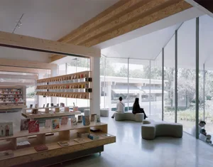 A modern bookstore featuring minimalist architectural elements, including wooden shelves, concrete floors, and large glass wi