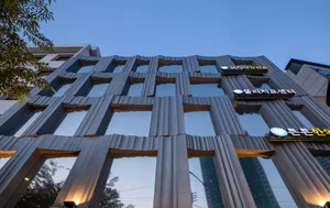 A modern building with a metallic facade and reflective glass windows.