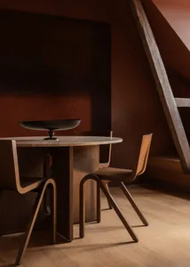 Modern, minimalist dining room with a wooden table, chairs, and minimalist decor.