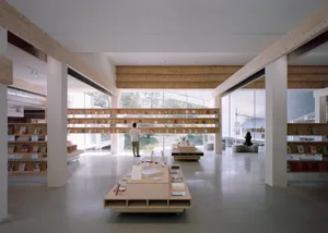 A spacious, modern reading room with wooden shelves and a concrete floor.