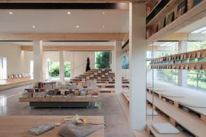 A modern library interior with wooden shelving and concrete flooring.