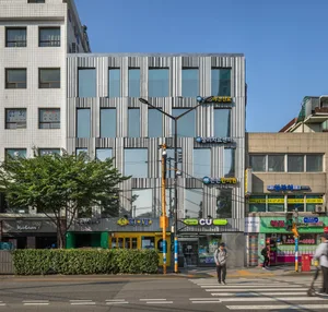 A modern office building with metallic exterior panels in an urban setting.