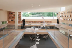 A modern Minimalist bookstore with wooden shelves and hanging papers