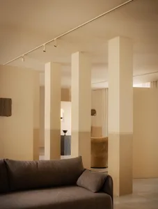 A modern living room with neutral-colored walls and furniture, featuring minimalistic design elements and a sense of openness