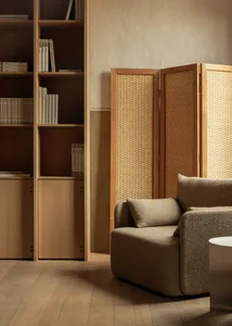 A minimalist living room featuring wooden furniture and textile accents.