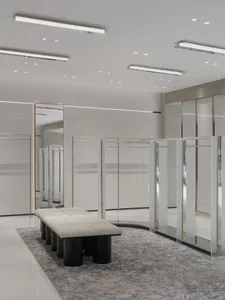 A minimalist retail interior with glass cabinets and a white bench.