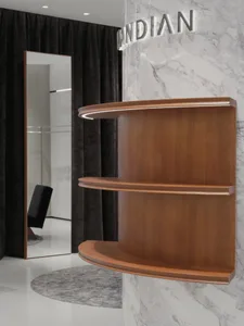 A modern interior design featuring a wood shelf with a curved edge, illuminated by LED lighting, against a white marble wall.