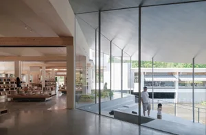 A spacious, modern library with glass walls and a high ceiling.