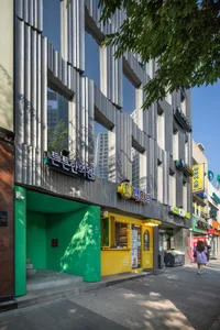 Modern retail storefront with metallic cladding on a sunny day.