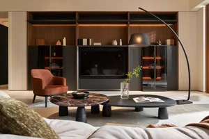 A modern minimalist living room with a large marble table, a comfortable sofa, and a sleek entertainment unit with ambient li