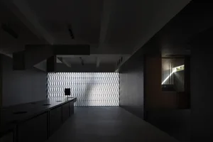 A modern industrial office with a metal mosaic tile wall and dark interior design elements.