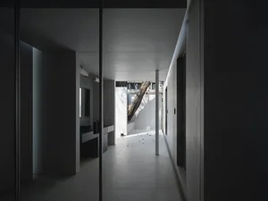 A minimalist living room featuring concrete walls and modern furniture.