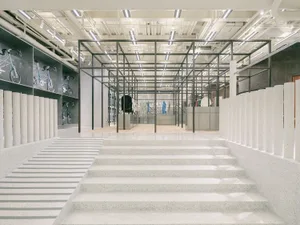 A retail store interior featuring concrete, metal, and glass elements.