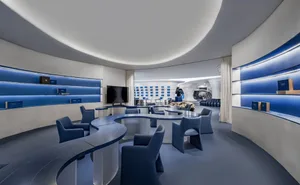 Modern office space featuring blue metal walls and white seating.