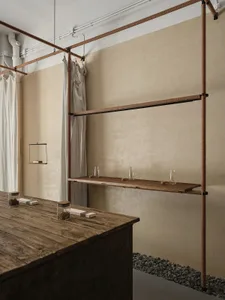 Industrial-style coffee shop interior featuring exposed wood, metal, and rope shelving.